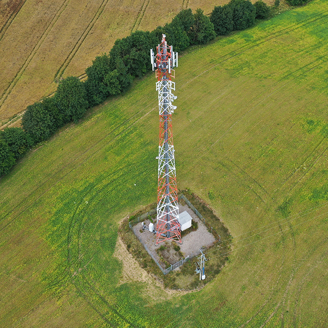 A cell tower standing tall in the middle of a field