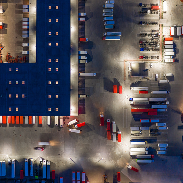 An aerial view of semi trucks and eighteen wheelers parked at loading docks