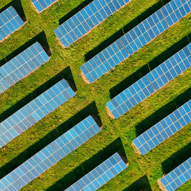 Looking down at rows of solar panels on a solar farm