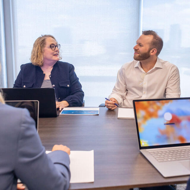 Accelerate's Brenda Hurst and Tyler Levy talking at a table