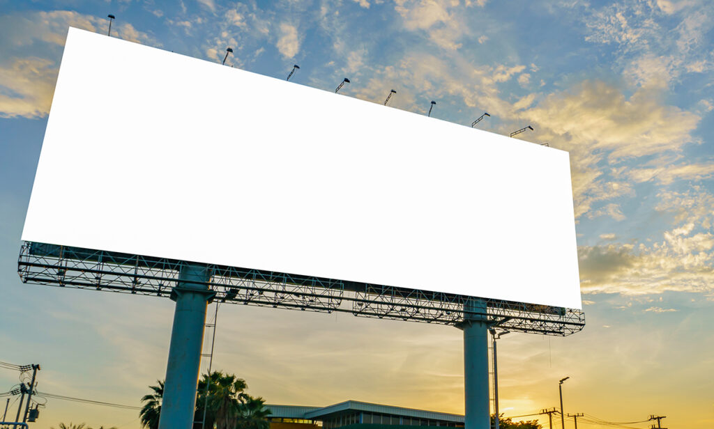 An empty billboard in front of a city skyline
